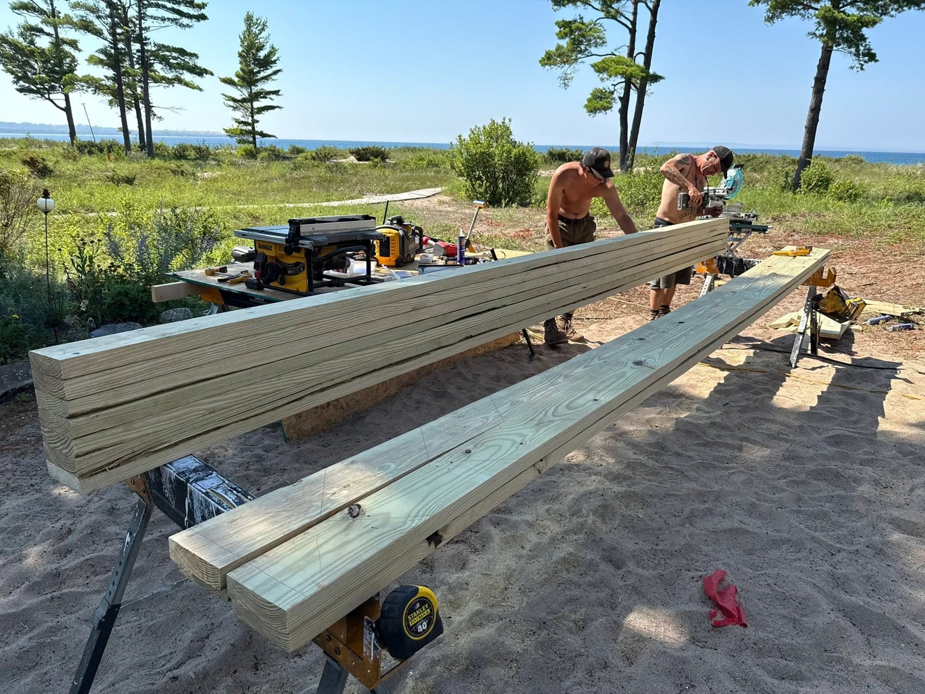 Lumber beams being cut on a worksite near the water