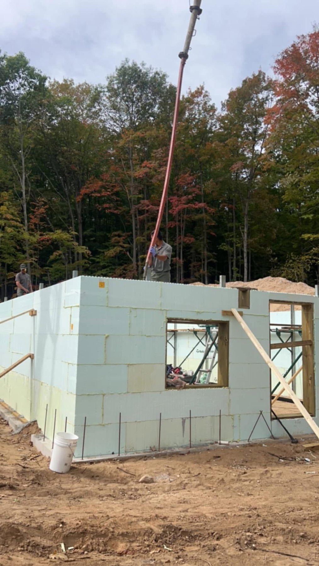 Insulated concrete walls rising on a new build with a crane overhead